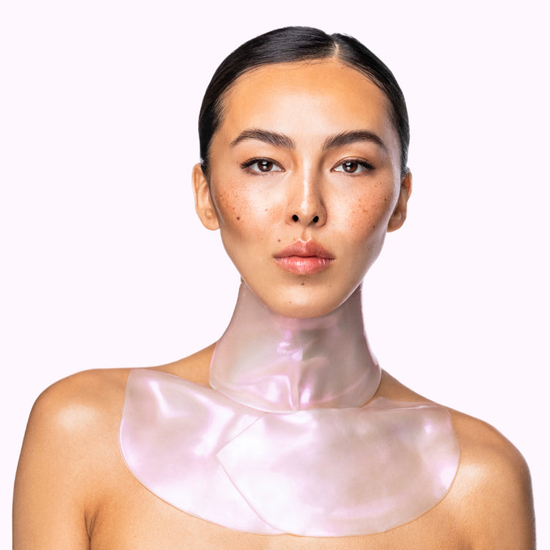 A woman using Gold Repair Neck and Décolleté Masks.