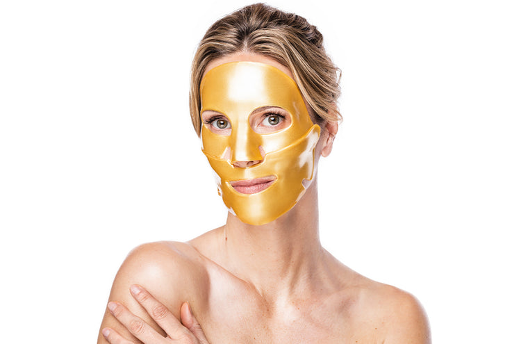 Woman wearing a gold face mask against a white background