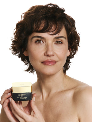 Woman holding the rich cream against a white background