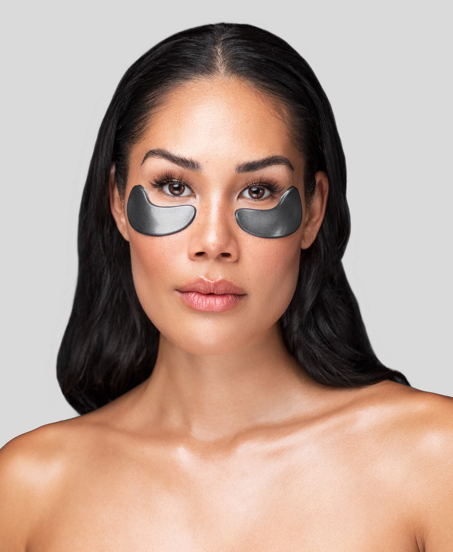 A woman using a Black Pearl Detox Collagen Eye Mask.