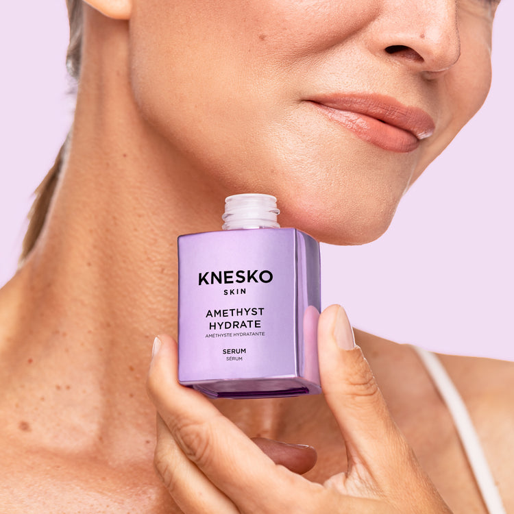 woman holding a jar of amethyst collagen serum