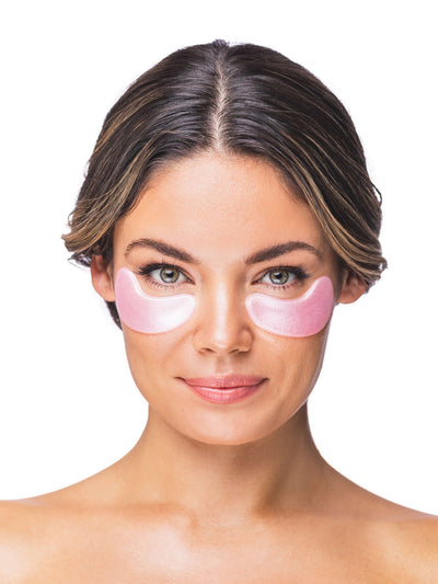 Woman wearing pink eye patches on a white background