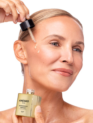 Woman applying Knesko serum t to her face with a dropper.