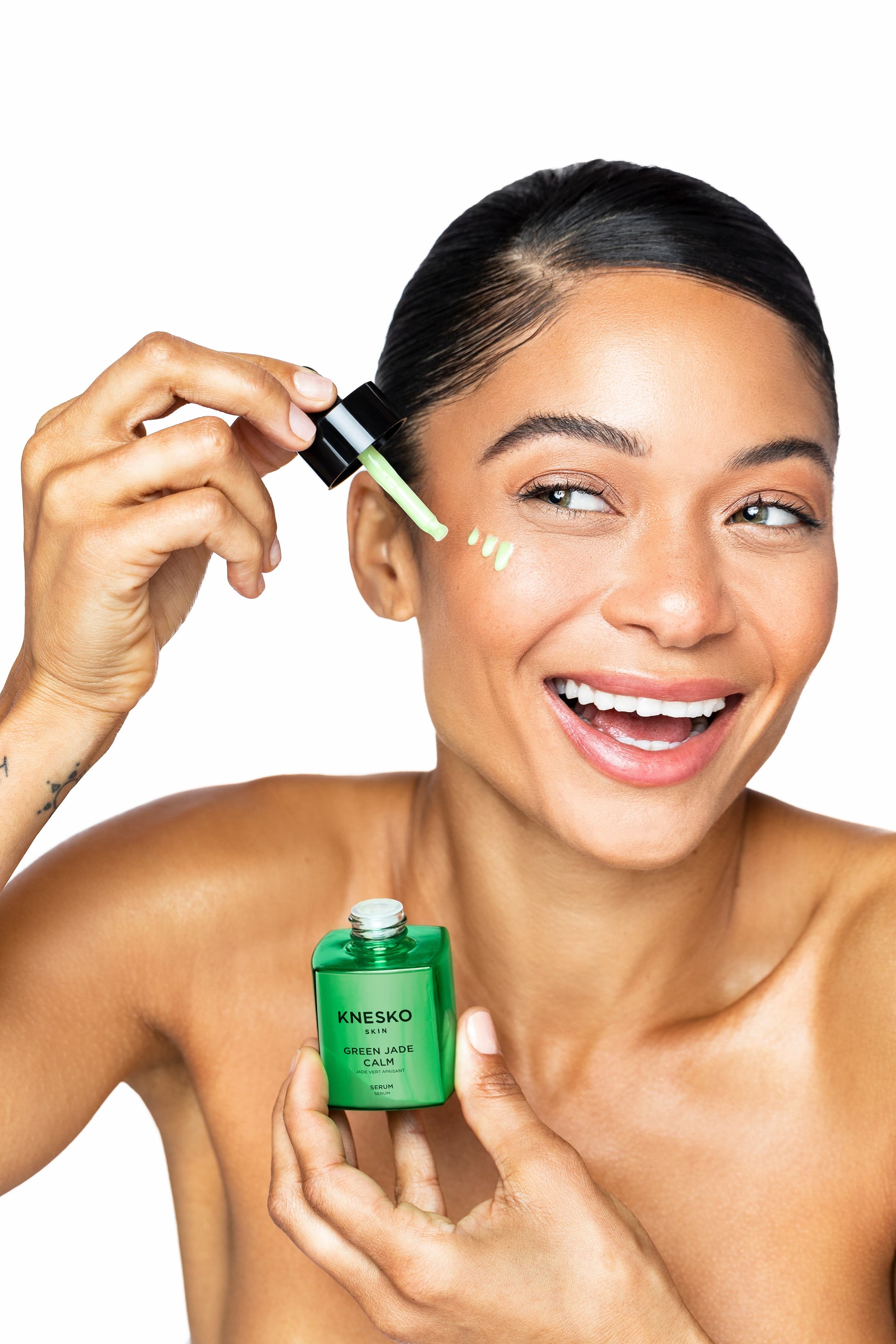 woman using green jade serum on face
