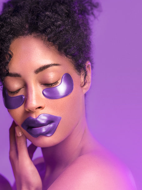 A woman using a lip mask and eye masks from the Amethyst Hydrate collection.