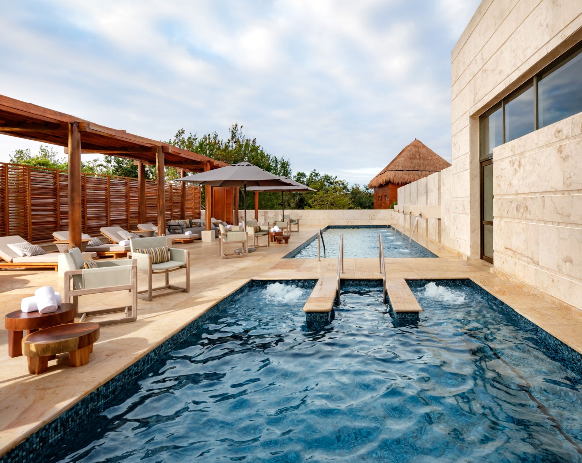 Outdoor pool area with lounge chairs and a building in the background
