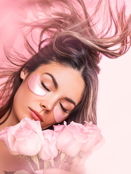 A woman using eye masks from the Rose Quartz Antioxidant collection.