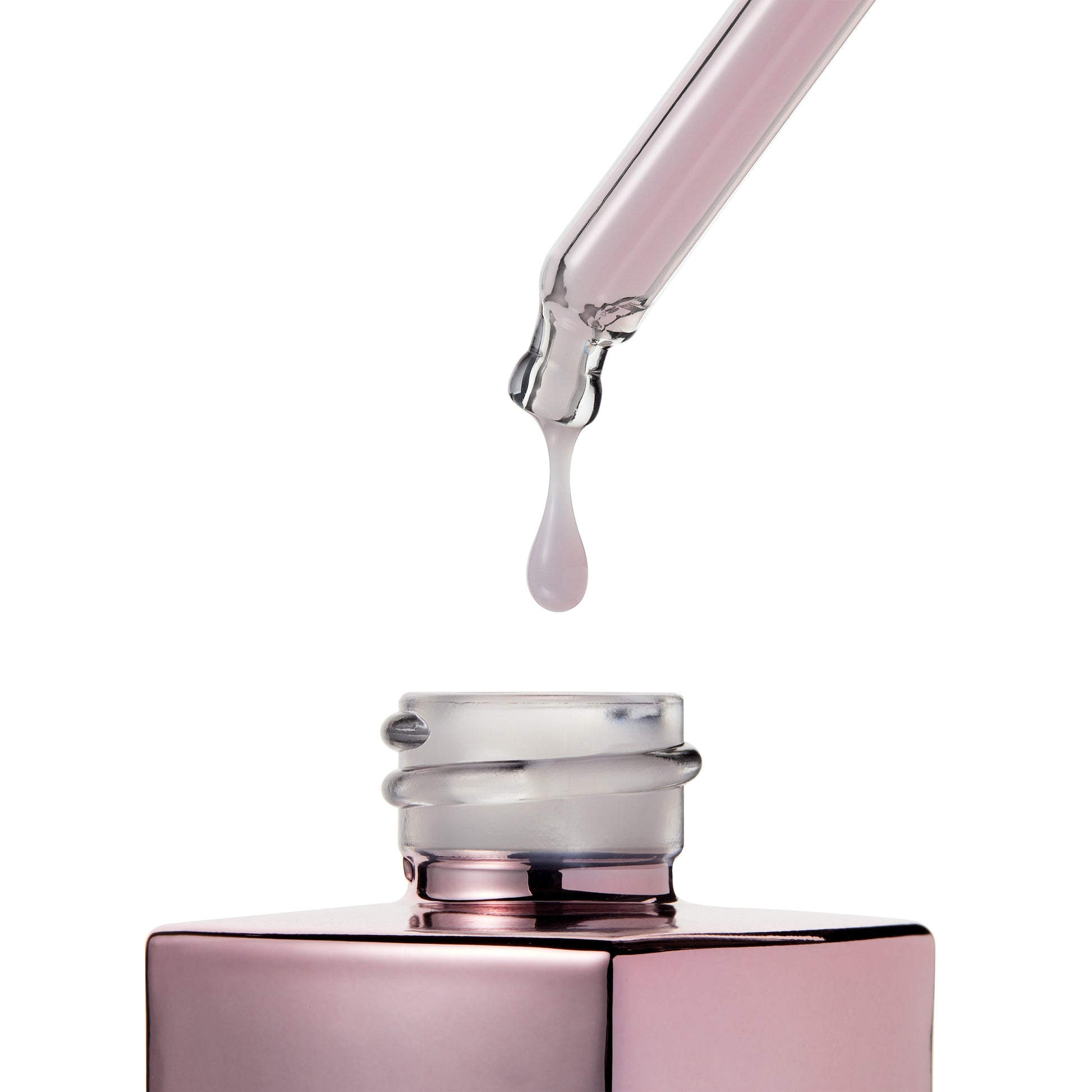 serum dropper dripping into pink bottle.