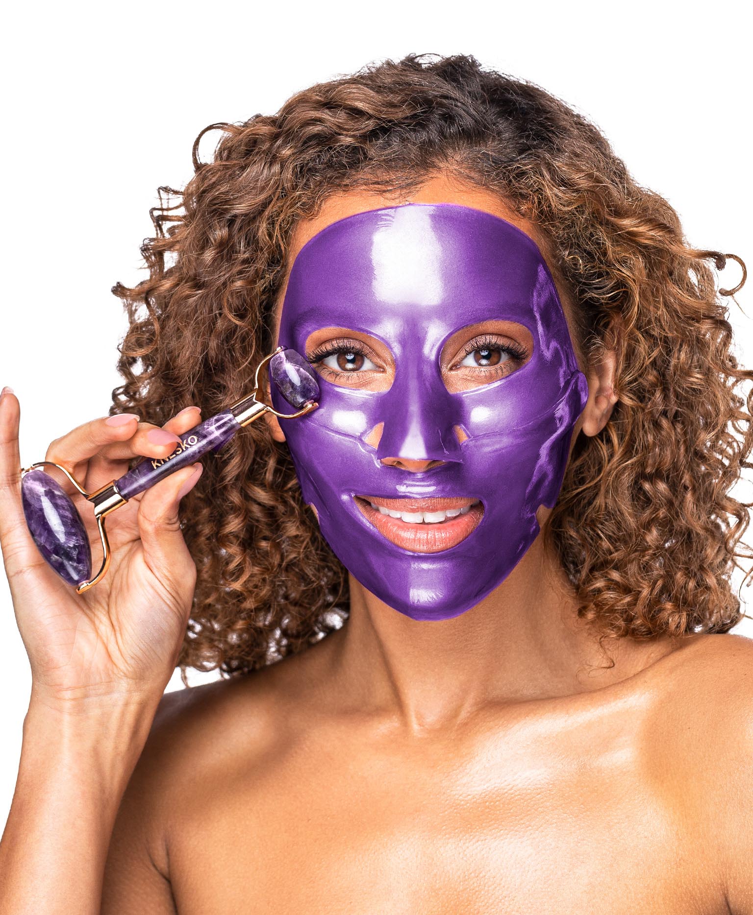 A woman using the Amethyst Hydrate Collagen Mask & Amethyst Gemstone Roller Set.