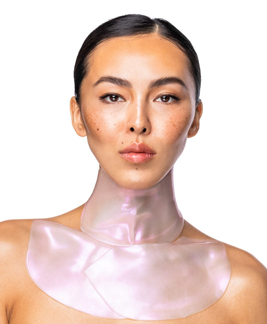 A woman using a Diamond Radiance Neck and Decollete Mask Combo.